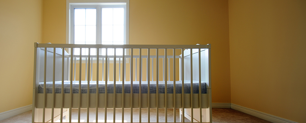 A crib in an empty sunlit room